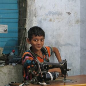 Bangladeshilainen poika ompelukoneen ääressä