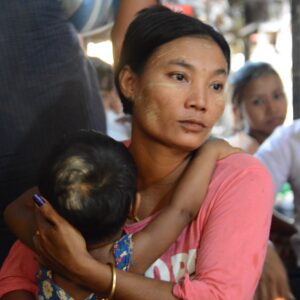 Myanmarilainen nainen pitelee sylissään pientä lasta