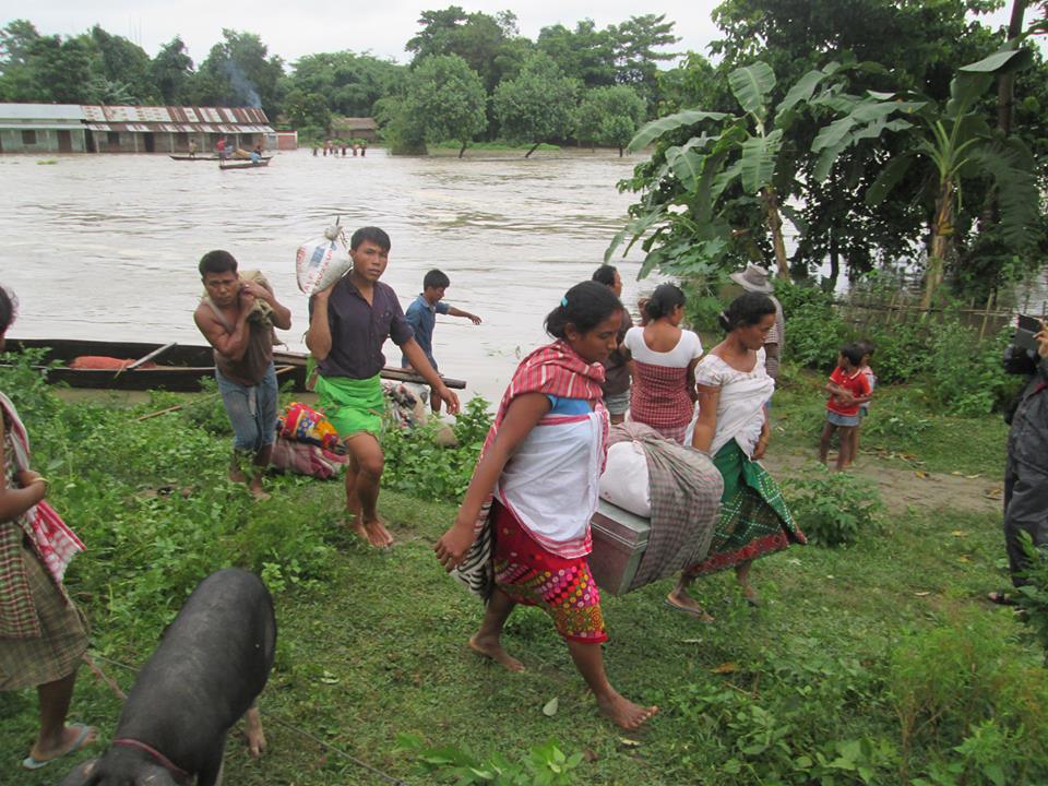 Ihmisiä tulvivalla joella Intian Assamissa