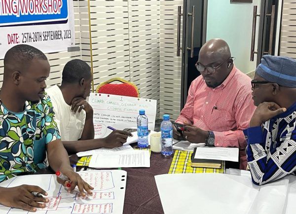 Neljä ihmistä pöydän ympärillä ilmastonmuutokseen sopeutumiseen liittyvässä Oikeudenmukainen siirtymä -työpajassa Nigeriassa