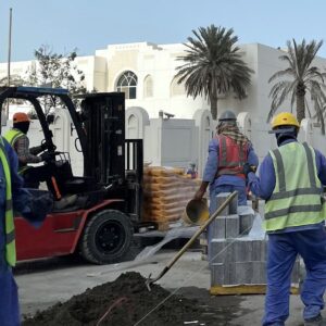Työntekijöitä työskentelemässä kadunrakennustyömaalla Qatarissa vuoden 2022 jalkapallon MM-kisojen alla.