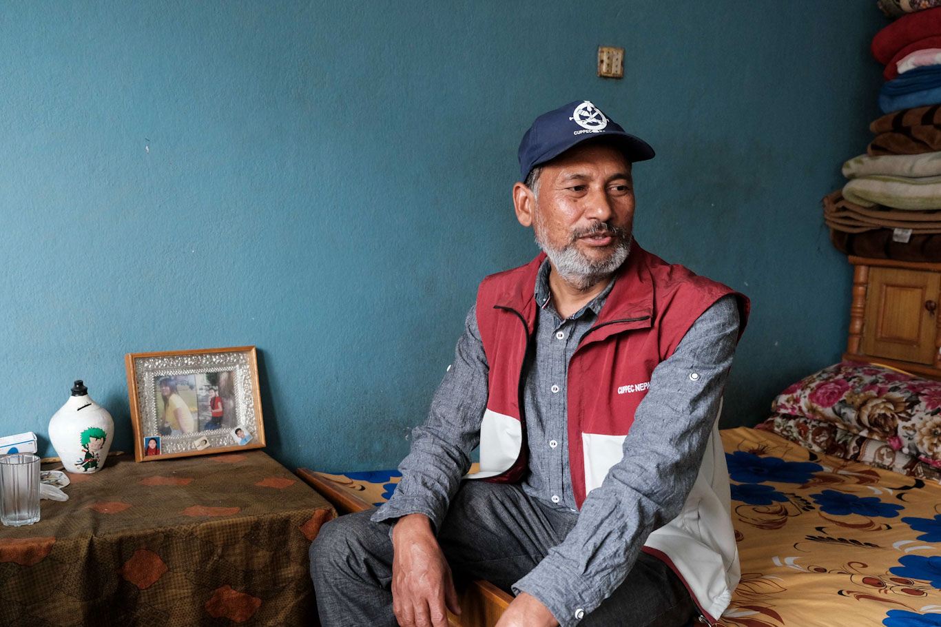 Nepaliin Qatarista palannut siirtoytyöntekijä Sushant Raya istuu turkoosiseinäisessä huoneessa
