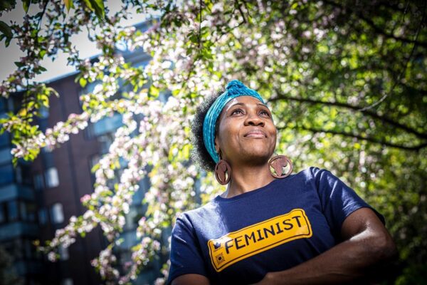Teollisuusalojen työntekijöiden kattojärjestön IndustriALLin työntekijä, taloustieteilijä Tendai Makanza Feminist-paidassa omenapuun alla