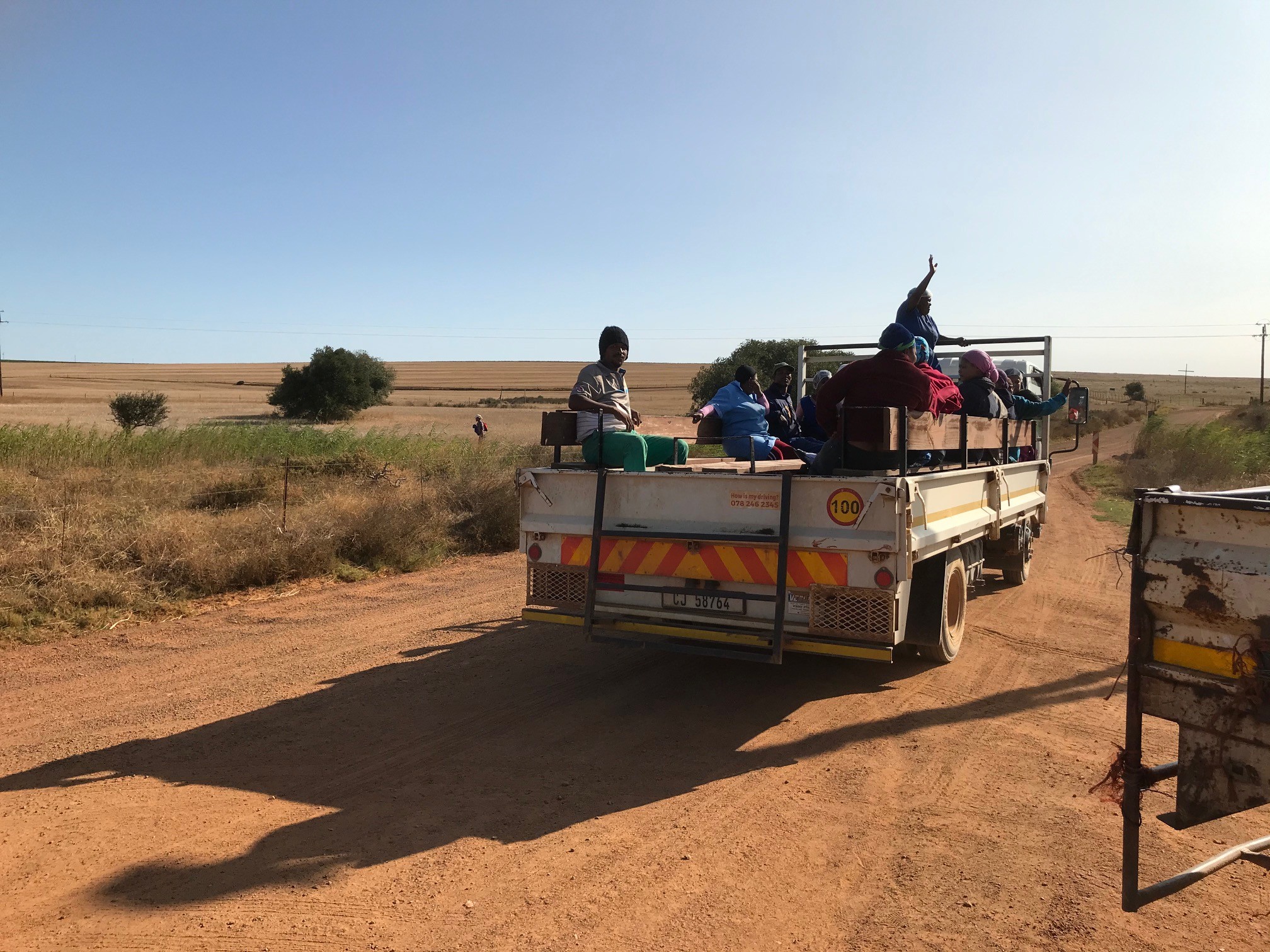 Eteläafrikkalaisia viinitilan työntekijöitä kuorma-auton lavalla keskellä autiota maaseutua