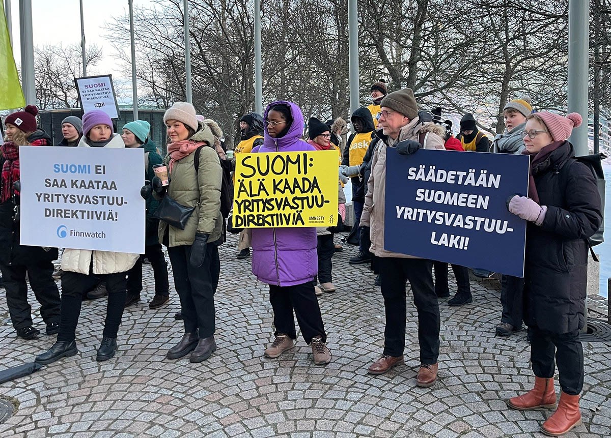 Järjestöjen mielenosoitus EU:n yritysvastuudirektiivin puolesta helmikuussa 2024. Mielenosoittajia kylttien kanssa eduskuntatalon edustalla.