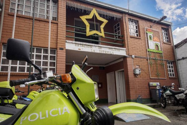 Poliisimoottoripyöriä ja La Estrellan punatiilinen poliisiasema Kolumbiassa