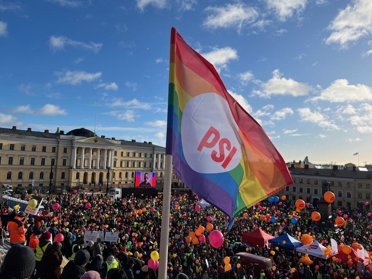 Sateenkaarilippu liehuu Senaatintorin STOP Nyt -mielenosoituksessa helmikuussa 2024