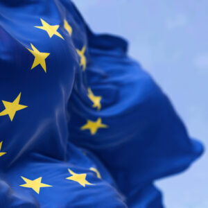 EU:n lippu liehuu lähikuvassa sinistä taivasta vasten
